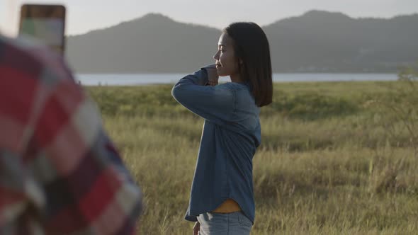 Teenage females take pictures on the smartphone while sunset having fun together a summer traveling.