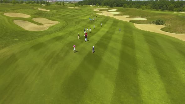 Group of kids running on golf fields on sunny day alt
