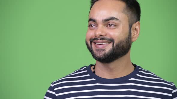 Young Happy Bearded Indian Man Smiling While Thinking