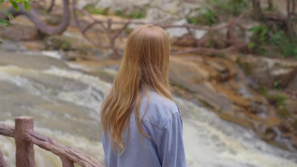 A Young Woman Visits Waterfall in Mountains. Travel To Dalat Concept alt