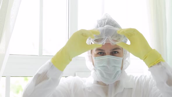 Portrait of Man Doctor Takes Off Protective Mask, Glasses, Hood in Pandemic.