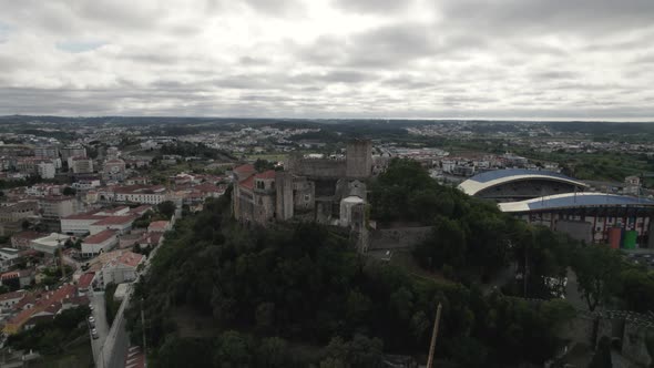 Leiria Castle perched on hilltop overlooking city; slow drone pan