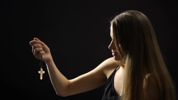 Beautiful Woman Looking at Wooden Cross in Hand and Hugging It, Religion alt