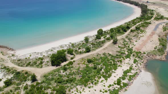 Aerial over crystal clear turquoise waters at Binh Tien Beach in Vietnam. alt