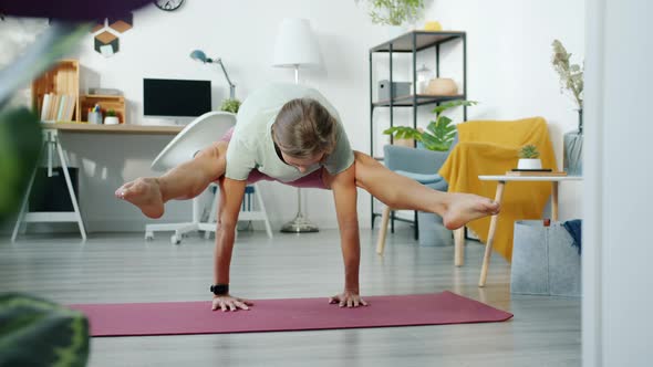 Female Yoga Student Exercising at Home Doing Arms Balancing Asana on Mat alt