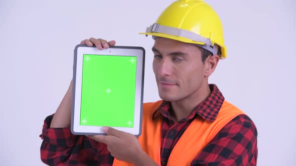 Face of Young Happy Hispanic Man Construction Worker Showing Digital Tablet