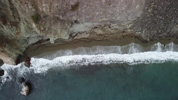 Aerial View From Above on Calm Azure Sea and Volcanic Rocky Shores alt