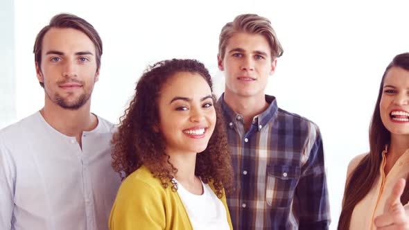 Portrait of smiling executives showing thumbs up alt
