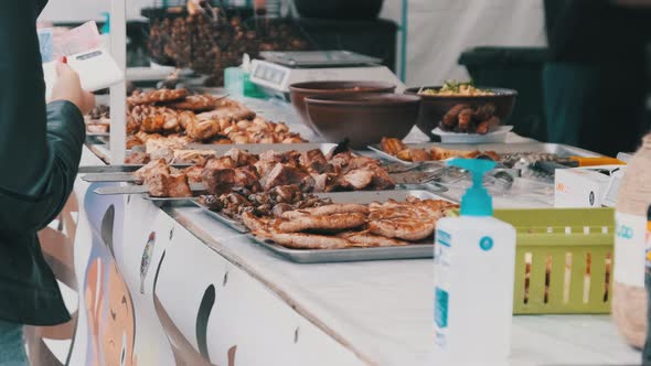 Buyer Buys Grilled Food and Transfers Money To the Seller at a Street Festival alt