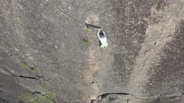 Top View: a Young Brave Man Descends a Rock Wall Without Insurance