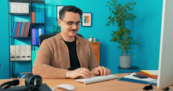 Elegantly Dressed Handsome Man Sitting in Front of the Computer Monitor in the Office and alt