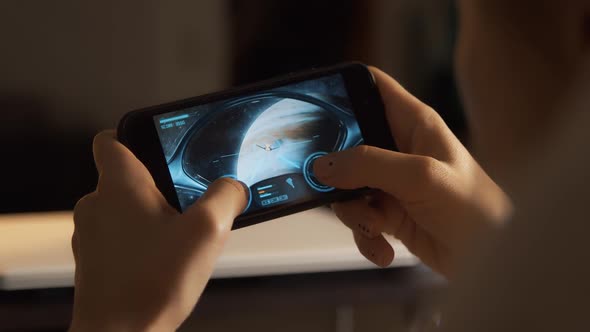 Girl Plays With Smartphone Space Shooter Video Game At Home alt