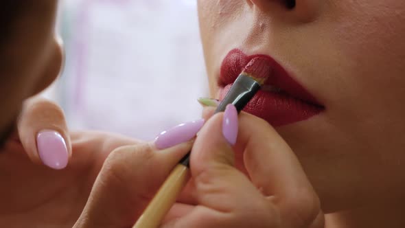 Makeup Artist Applying Red Lipstick alt