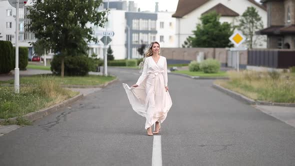 Cheerful Woman with Beautiful Big Blue Eyes, Long Fair Hair, White Hat in King White Dress Poses for