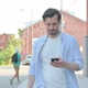 Man Celebrating on Smartphone While Walking in Street in Slow Motion - VideoHive Item for Sale