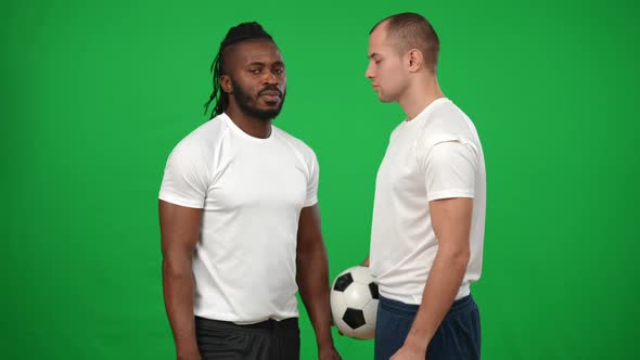 Serious Motivated African American and Caucasian Men Standing at Chromakey Background Face to Face alt