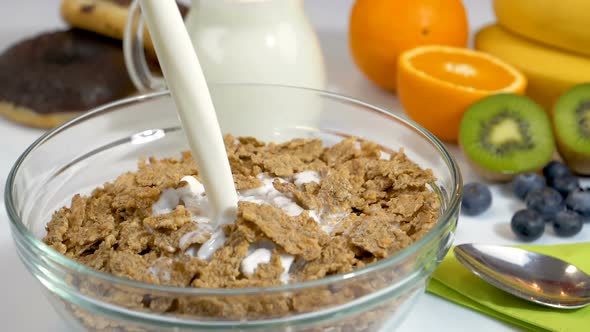Pouring Milk on Cereals Flakes for Breakfast alt