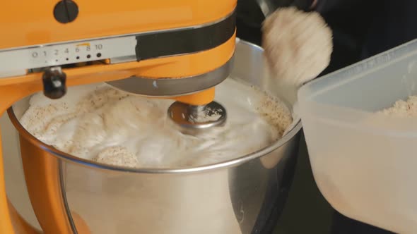 The Pastry Chef Puts Hazelnut and Almond Flour Into the Bowl of a Working Mixer Where a Biscuit is