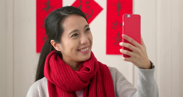 Chinese woman taking selfie and holding with red packet in lunar new year holiday alt