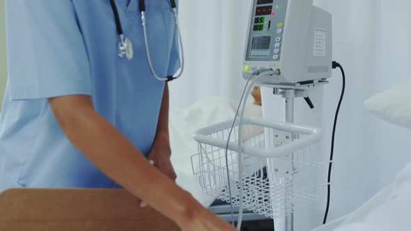 Side view of African american female doctor talking with female patient in ward at hospital 4k alt