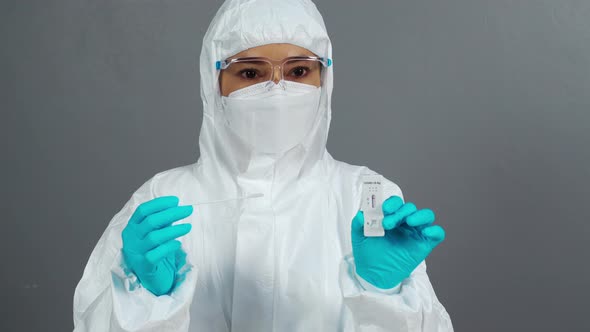 doctor in PPE suit holding Coronavirus(Covid-19) negative test result with Antigen Rapid Test kit