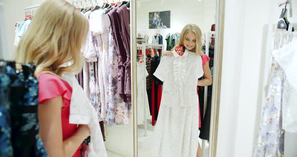 Woman Trying Dress in Front of Mirror