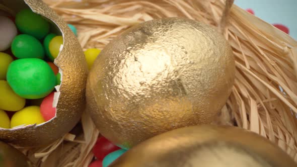 Easter Eggs Painted in Gold Color on Blue Wooden Table Close Up
