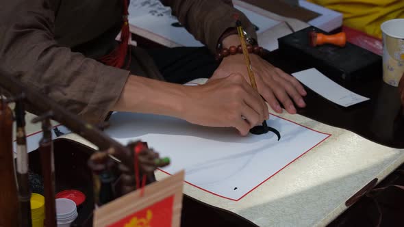 Vietnamese scholar writing calligraphy at lunar new year