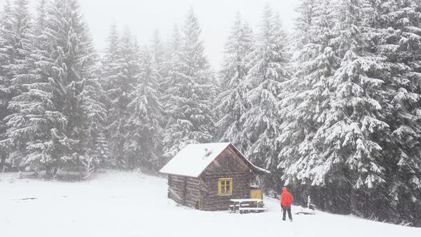 Man Hiker in Red Jacket Walking Into a Wooden House