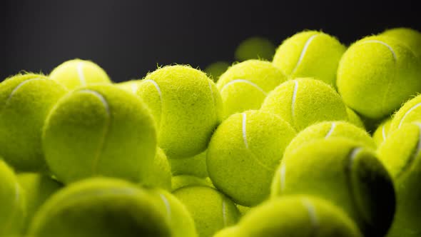 Seamless looping animation.Set of many tennis balls on the black background. alt