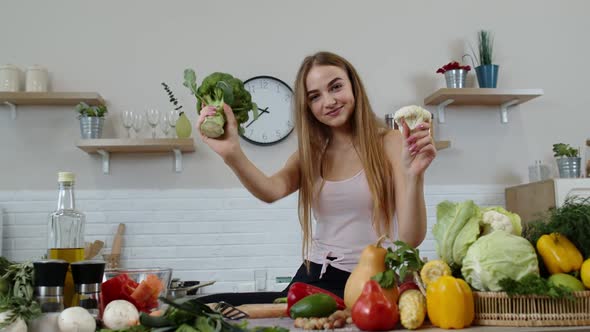 Girl Recommending Eating Raw Vegetable Food. Showing Broccoli and Cauliflower. Weight Loss, Diet alt