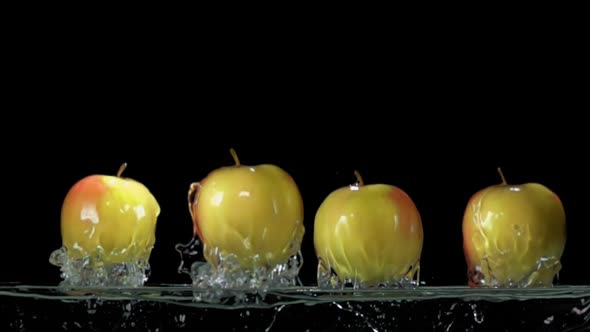 Four Green Apples are Bouncing From the Water with Splashes in Super Slow Motion alt