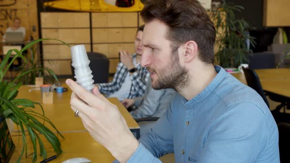 Serious Engineer Examining Detail and Using Computer