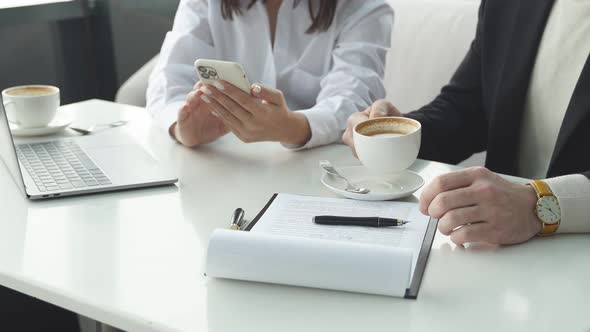 Business Lady Uses a Smartphone at a Business Meeting with a Man a Business Colleague an Image