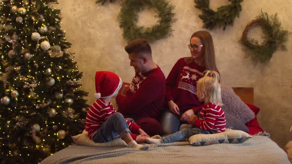 Cheerful Family Exchanging Gifts on Christmas Day