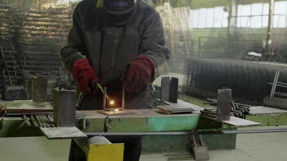 Man welding iron details at factory