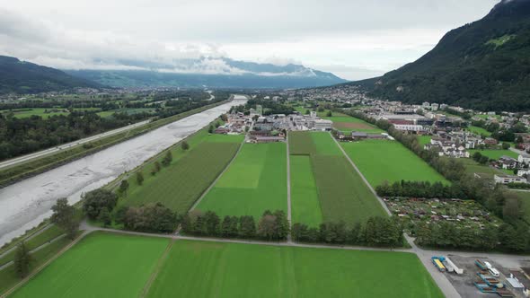 Liechtenstein with Houses on Green Fields in Alps Mountain Valley Aerial View alt