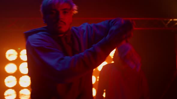 Dancer Guy Making Rhythmic Movements with Friends in Nightclub alt