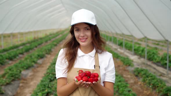 Smiling Woman Enjoying Good Harvest in Greenhouse alt