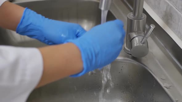 the Hands of a Dental Assistant Sterilize the Dentist's Working Tool By Washing It Under the alt