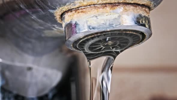 Water Flows From An Old Contaminated Tap With Calcium And Grime Into A