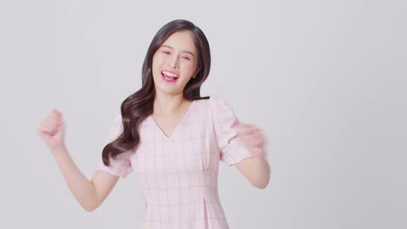 Happy attractive asian young woman dancing isolated on white background alt