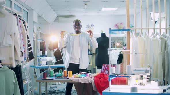 A Designer is Explaining for the Camera How to Use a Tape Measure alt