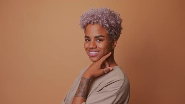 Lovely Blonde African Woman Keeps Hand on Face Has Gentle Smile Looks Satisfied alt