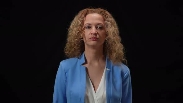 Embarrassed Caucasian Woman Holding Head in Hands Standing in Camera Flashes at Black Background alt