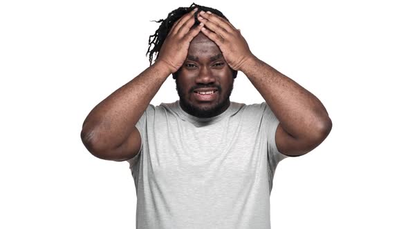 Portrait of Nervous Dark Skinned Guy with Afro Pigtails Grabbing His Head in Misunderstanding or alt