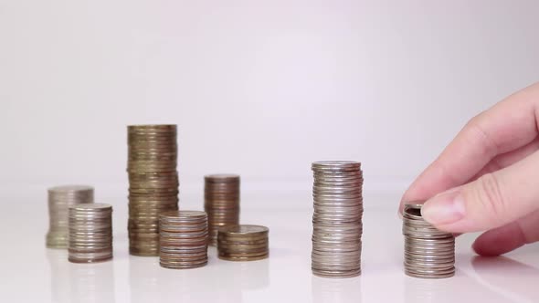 A woman's hand puts coins on the table and counts them. Investment concept. Metallic currency alt