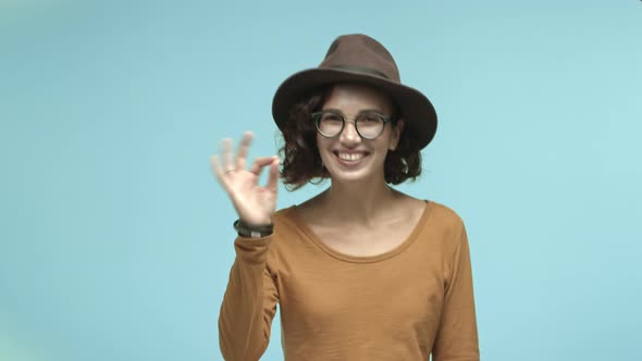 Cheerful Girl with Hipster Hat Laughing Showing OK Sign in Approval Like Something Cool Approve and