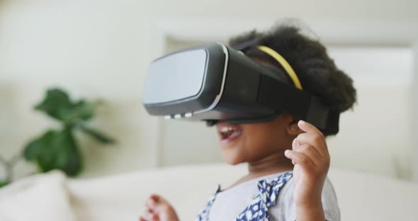 Smiling african american girl playing with vr headset in living room alt