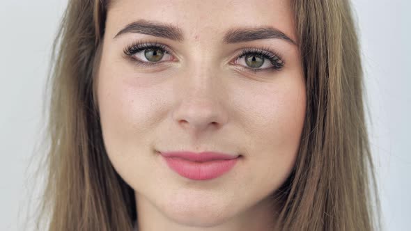 Close Up Portrait of an Attractive Teen Female Opening Her Eyes and Smiling alt